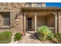 Inviting front porch with stone accents, a covered entrance, and decorative plants at 18519 N 94Th St, Scottsdale, AZ 85255