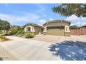 A well-maintained home with a two-car garage and desert landscaping, with a brick paver driveway at 20520 E Mockingbird Dr, Queen Creek, AZ 85142