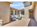 A cozy outdoor patio is furnished with a neutral colored seating set for relaxing and entertaining at 20520 E Mockingbird Dr, Queen Creek, AZ 85142