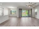 Open living room with tile floors, ceiling fan, and sliding glass doors leading to a backyard at 21090 E Camina Buena Vis, Queen Creek, AZ 85142
