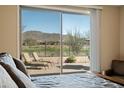 Relaxing bedroom view showcasing a patio with scenic views, accessible through a sliding glass door at 2214 W Muirfield Dr, Anthem, AZ 85086