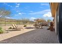 A beautiful patio with lounge chairs, dining area, and grill, perfect for outdoor relaxation and entertaining at 2214 W Muirfield Dr, Anthem, AZ 85086