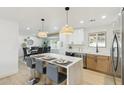 Stylish kitchen with a marble island and modern pendant lighting, seamlessly connecting to the adjacent dining area at 2244 E Janice Way, Phoenix, AZ 85022