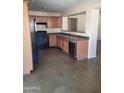 Cozy kitchen with wood cabinets, black appliances, and a breakfast bar at 24930 W Dove Mesa Dr, Buckeye, AZ 85326