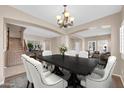 Elegant dining room features a large black table with white chairs and a chandelier, with access to other living areas at 2987 E Powell Way, Gilbert, AZ 85298