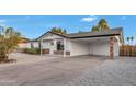 Charming single-story home with a long driveway, covered parking, and low maintenance landscaping at 3037 E Pueblo Ave, Mesa, AZ 85204