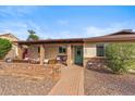 Inviting home exterior with covered porch, brick accents, desert landscaping, and walkway to green front door at 3221 N 41St Pl, Phoenix, AZ 85018