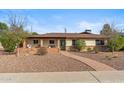 Charming single-story home with desert landscaping, brick accents and covered porch with seating area at 3221 N 41St Pl, Phoenix, AZ 85018