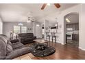 Bright living area featuring hardwood floors and a ceiling fan, seamlessly connects to the adjacent dining and kitchen areas at 3301 S Goldfield Rd # 2034, Apache Junction, AZ 85119