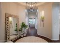Inviting foyer with dark hardwood floors, light-colored walls, decorative mirror, and potted plants at 3634 E Sands Dr, Phoenix, AZ 85050