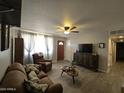 Comfortable living room with a ceiling fan, wood-look tile flooring, and a cozy seating area at 3932 W Lawrence Ln, Phoenix, AZ 85051
