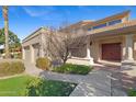 Inviting front entrance showcasing a three-car garage, double doors, and mature landscaping at 4066 E Grandview St, Mesa, AZ 85205