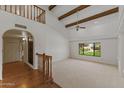 Bright living room with high ceilings, wooden beams, and staircase leading to the second floor at 4066 E Grandview St, Mesa, AZ 85205