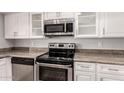 Close-up of modern stainless steel appliances, including oven, microwave, and dishwasher, set against granite countertops at 4701 E Walatowa St, Phoenix, AZ 85044