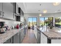 Modern kitchen with stainless steel appliances, granite countertops, and an expansive golf course view at 7400 E Gainey Club Dr # 123, Scottsdale, AZ 85258