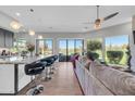 Inviting living room featuring bar seating, hardwood floors, and expansive views of the golf course at 7400 E Gainey Club Dr # 123, Scottsdale, AZ 85258