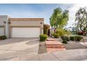Inviting home with a two-car garage, desert landscaping, and a colorful flowering vine near the entryway at 8401 N 84Th Pl, Scottsdale, AZ 85258