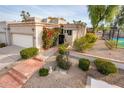 Charming home exterior featuring desert landscaping, a secure gated entrance, and a two car garage at 8401 N 84Th Pl, Scottsdale, AZ 85258