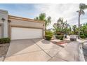 Southwestern home showcasing a two-car garage, desert landscaping, and a lush green lawn at 8401 N 84Th Pl, Scottsdale, AZ 85258