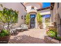 Charming front courtyard with stone fountain, seating, and flowering plants creating a welcoming entrance at 9834 E Voltaire Dr, Scottsdale, AZ 85260