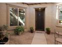 Inviting courtyard with a secure door, a water feature, and vibrant potted plants at 10835 E Thornton Ave, Mesa, AZ 85212