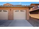 Attached two-car garage with a light-colored door and paved driveway at 11500 E Cochise Dr # 1094, Scottsdale, AZ 85259