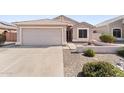 Single story home with desert landscaping, light stucco, tiled roof and two car garage at 1559 E Peregrine Trl, Casa Grande, AZ 85122