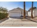Lovely single-story home featuring a two-car garage, desert landscaping and mature palm trees along the walkway at 17406 N 28Th Dr, Phoenix, AZ 85053