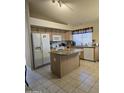 Well-lit kitchen with an island, granite countertops, wooden cabinets, and appliances at 17821 N Woodrose Ave, Surprise, AZ 85374