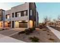 Modern townhome featuring a two-car garage, xeriscaped yard and a neutral colored exterior at 1936 W Kinfield Trl, Phoenix, AZ 85085