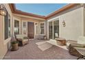 Cozy front patio with charming brickwork, comfortable seating, and a welcoming entryway at 29534 N 128Th Ln, Peoria, AZ 85383