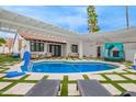 Inviting backyard oasis featuring a sparkling pool, lounge chairs, and covered seating area at 2629 S Country Club Way, Tempe, AZ 85282
