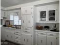 Well-lit kitchen featuring white cabinetry, stylish fixtures, and a functional layout for an enjoyable cooking experience at 2650 W Union Hills Dr # 272, Phoenix, AZ 85027