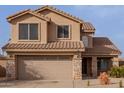Charming home with a two-car garage, complemented by stone accents and a tiled roof at 3234 E Marco Polo Rd, Phoenix, AZ 85050