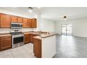Open concept kitchen with stainless steel appliances, breakfast bar, and tile flooring at 328 W Dragon Tree Ave, San Tan Valley, AZ 85140