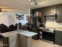 Open kitchen with stainless steel appliances and island with a view into an adjacent living room at 3307 W Ocotillo Rd, Phoenix, AZ 85017