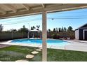 A luxurious backyard featuring a sparkling pool, gazebo, artificial grass, and a privacy fence, creating an ideal outdoor oasis at 4631 W Mcrae Way, Glendale, AZ 85308