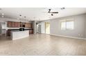 Open-concept living space with tile floors, a ceiling fan, and access to the kitchen at 4695 N 204Th Ave, Buckeye, AZ 85396