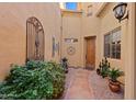 Inviting front entrance with a secure courtyard and beautifully landscaped walkway to a wooden front door at 5370 S Desert Dawn Dr # 39, Gold Canyon, AZ 85118