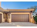 This expansive garage features a stylish carriage-style door and accent lighting under a clear blue sky at 5370 S Desert Dawn Dr # 39, Gold Canyon, AZ 85118