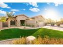 Beautifully landscaped single-story home with lush green lawn, mature trees, and a two-car garage at 835 E Virgo Pl, Chandler, AZ 85249