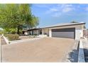 Spacious single-story home features a white brick facade, xeriscaped front yard, and long concrete driveway at 8419 N 51St Dr, Glendale, AZ 85302