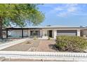Well-maintained single-story home features a white brick facade, xeriscaped front yard, and a two-car garage at 8419 N 51St Dr, Glendale, AZ 85302