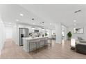 Open-concept kitchen features a large island with seating, stainless steel appliances, and white cabinetry at 8419 N 51St Dr, Glendale, AZ 85302