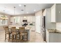 Bright kitchen with white cabinets, stainless steel appliances, granite countertops, and a breakfast bar at 9144 W Surrey Dr, Peoria, AZ 85381