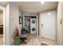Convenient laundry area with a stacked washer and dryer unit and tile flooring at 10030 W Indian School Rd # 203, Phoenix, AZ 85037