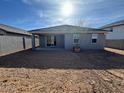 Backyard featuring dirt landscaping, gray block fencing, and a covered patio at 10035 S 23Rd Dr, Phoenix, AZ 85041