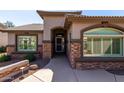 Close-up view of the home's entry featuring a security door and stacked stone accents at 10039 E Emerald Dr, Sun Lakes, AZ 85248