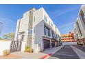 View of a three-story white home with black accents, featuring a private garage and modern design at 1717 E Morten Ave # 7, Phoenix, AZ 85020