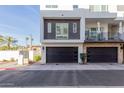 Contemporary three-story home with a black garage door and landscaped front yard at 1717 E Morten Ave # 7, Phoenix, AZ 85020